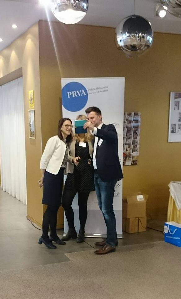 Christopher Reisinger takes a selfie two female colleagues in front of a PRVA roll-up 