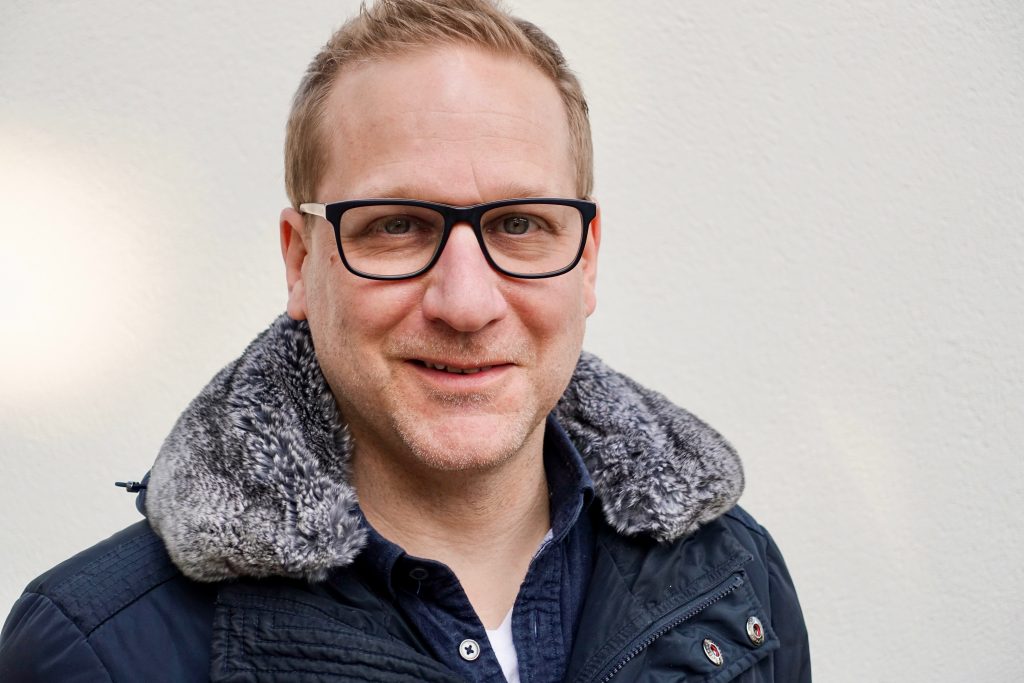 Alex Scheurer, ein blonder Mann mit Brille